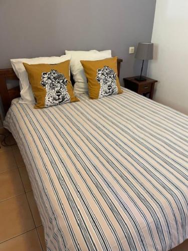 - un lit avec des draps et des oreillers à rayures dans l'établissement Residence Cap Bleu a Carro, à Martigues