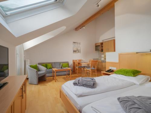 a bedroom with two beds and a living room at Aktiv- & Gesundheitsresort das GXUND - Thermeneintritt inklusive in Bad Hofgastein