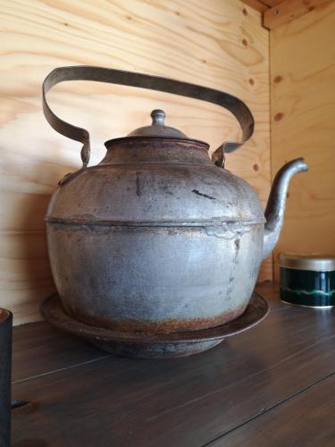 an old metal tea kettle sitting on a wooden floor at Kalix Riverside inn in Kalix