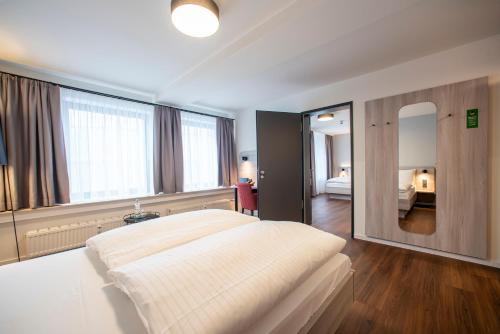 a bedroom with a large bed and a large window at Eden Hotel Früh am Dom in Cologne