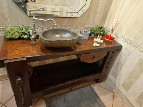 un lavandino in bagno con ciotola in pietra su un bancone in legno di Corte Della Varesina a Milano