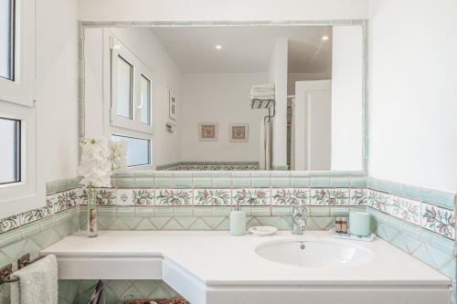uma casa de banho com um lavatório e um espelho em Villa Sa Gavina, Caló des Llamp em Porto Petro