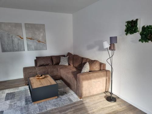 a living room with a brown couch and a table at Große Pause - Moderne Ferienwohnung nahe Steinhude in Hagenburg