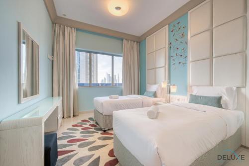 a hotel room with two beds and a window at Calm 3BR in The Signature Downtown by Deluxe Holiday Homes in Dubai