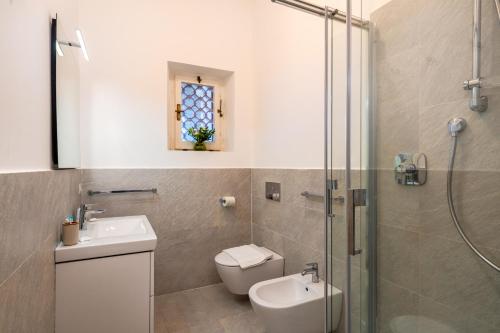 a bathroom with a toilet and a sink and a shower at Villa Escalina with private beach and A/C in Marciana Marina
