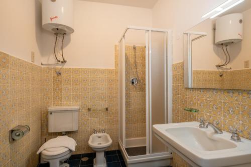 a bathroom with a toilet and a sink and a shower at Villa Escalina with private beach and A/C in Marciana Marina