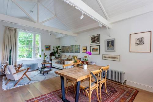 uma sala de estar com uma mesa e cadeiras e um sofá em Peaceful and Quiet 1BR Cottage in Camberwell em Londres