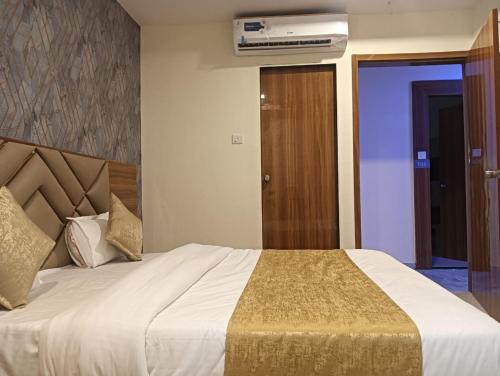 a bedroom with a large bed and a air conditioner at Hotel Lake View AC room in Vadodara