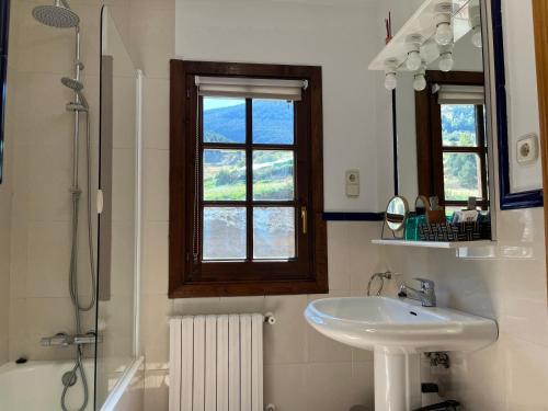 a bathroom with a sink and a mirror and a shower at Cases de Canillo-Casa Sant Serni in Canillo