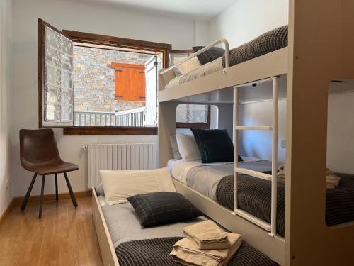 a room with two bunk beds and a chair at Cases de Canillo-Casa Sant Serni in Canillo