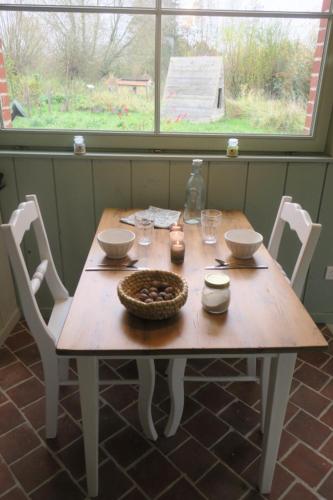 una mesa de madera con sillas y un tazón. en Les Jardins d'Olus, en Wandignies-Hamage