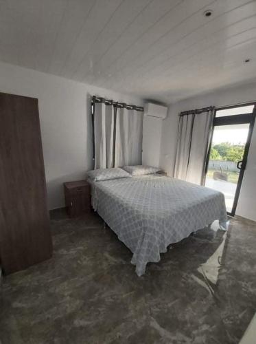 Teahupoo的住宿－Vaimiti Lodge，一间卧室设有一张床和一个大窗户