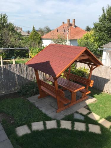 a wooden picnic table with a roof on top at Kamilla Apartman in Fonyód