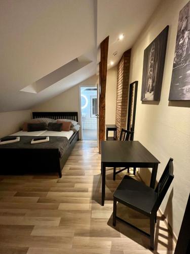 a bedroom with a bed and a desk and a table at Apartmány Kukučín in Košice
