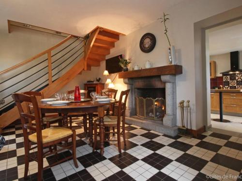 une salle à manger avec une table et une cheminée dans l'établissement Gîte charmant et lumineux près de Bagnoles de l'Orne, jardin, cheminée, télétravail, WIFI inclus - FR-1-497-14, à Antoigny
