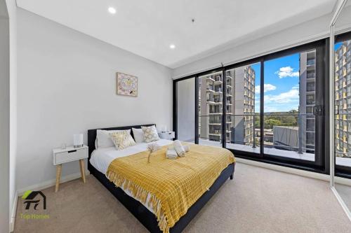 - une chambre avec un lit et une grande fenêtre dans l'établissement Entire 3 Bedroom in Bankstown, à Bankstown