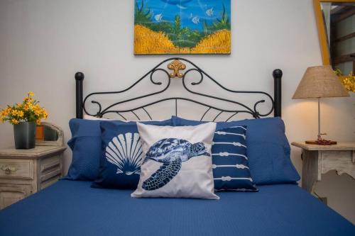 a bedroom with a bed with blue sheets and pillows at Casa Frente para o Mar em Búzios, Geribá Beach! in Búzios