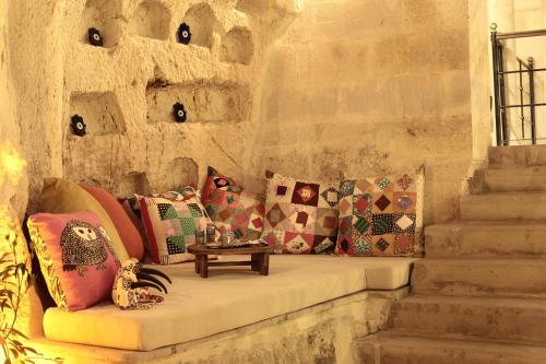 Habitación con sofá y almohadas. en Asuwari Suites Cappadocia en Urgup