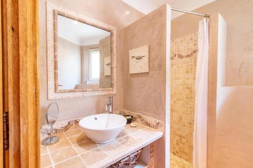 un bagno con lavandino e specchio di Mas de l'Olivette a Cotignac