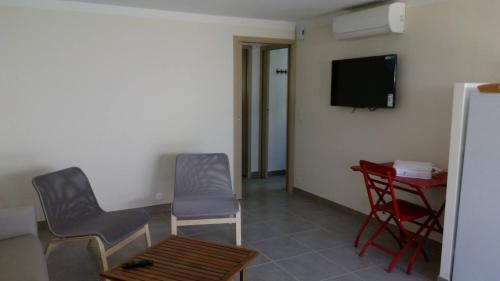 une pièce avec deux chaises, une table et une télévision dans l'établissement Nino - 2/4 personnes, à Nyons