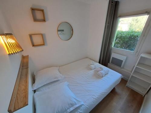 a small bedroom with a bed and a window at Mazet T2 - Domaine de la Pinède - Piscine Chauffée in Le Lavandou