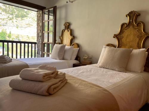 a bedroom with two beds with towels on them at Cases de Canillo-Casa Sant Joan de Caselles in Canillo