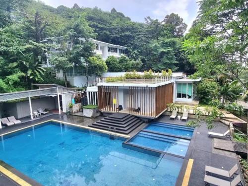 a house with a swimming pool in front of it at Tropical 1bedroom Apartment in Kamala Beach