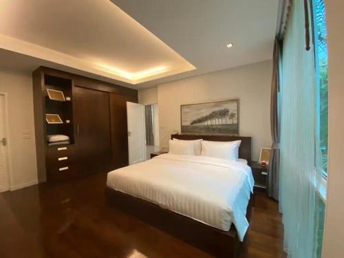 a bedroom with a large white bed and a window at Tropical 1bedroom Apartment in Kamala Beach