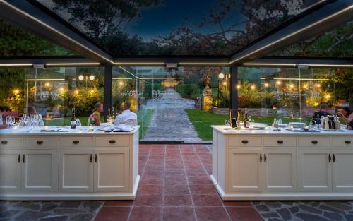 a restaurant with a view of a garden at night at Hotel Villa San Michele in Lucca