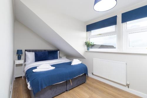 a bedroom with a blue bed and a window at Cosy Apartment Coventry City Centre in Coventry