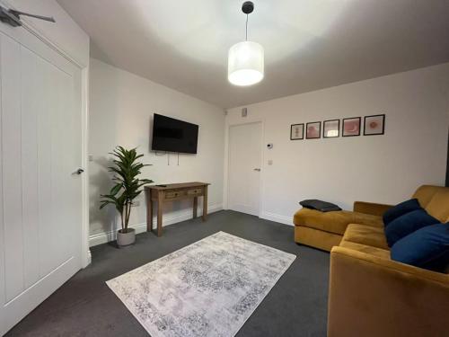 a living room with a couch and a tv at Homely 3 BR home for your family and friends in Gateshead