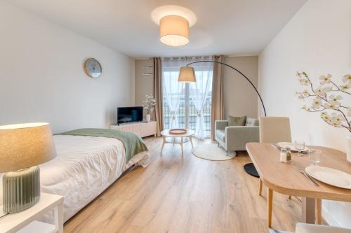 1 dormitorio con 1 cama y sala de estar en OVELIA Bourg-en-Bresse - Les Jardins de Voltaire en Bourg-en-Bresse