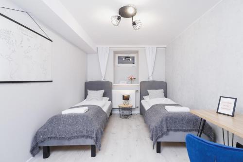 two beds in a room with a table and chairs at STU Theater Underground Apartment Syrokomli by Renters in Krakow