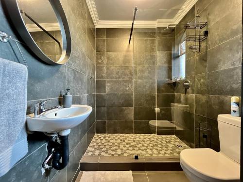 bagno con lavandino, servizi igienici e specchio di Jirah@Riverside a Centurion