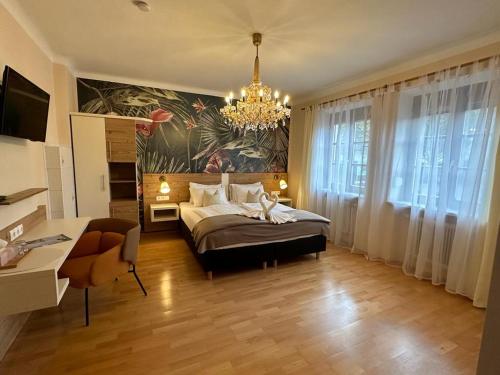 ein Schlafzimmer mit einem großen Bett und einem Kronleuchter in der Unterkunft Pension Amelie in Mörbisch am See