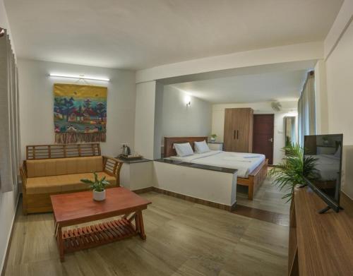 a hotel room with a bed and a living room at Clouds View Nature Resort in Koroth