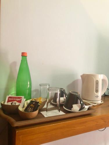 a wooden shelf with dishes and a green bottle at Wae Molas Hotel in Labuan Bajo