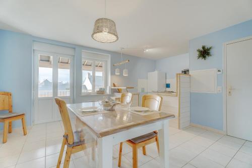 une cuisine avec une table, des chaises et un réfrigérateur dans l'établissement Les Ebihens, à Saint-Benoît-des-Ondes