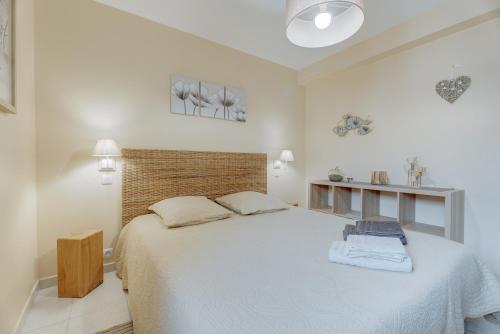 a white bedroom with a large bed in a room at Les Ebihens in Saint-Benoît-des-Ondes
