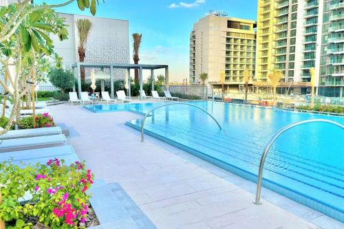 uma grande piscina com cadeiras e edifícios em Luxury Dubai Creek Balcony & View em Dubai