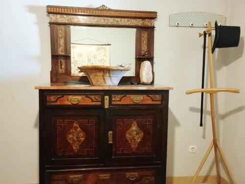 an old wooden dresser with a mirror on a wall at Rural EL METGE Penáguila con chimenea in Penáguila