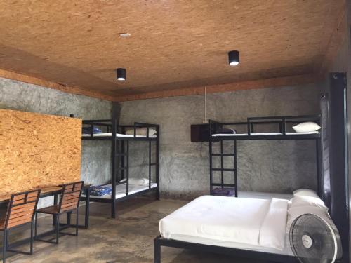 a room with a bed and two bunk beds at ชลลดา ริเวอร์ โฮมสเตย์ แก่งกระจาน in Ban Wang Malako