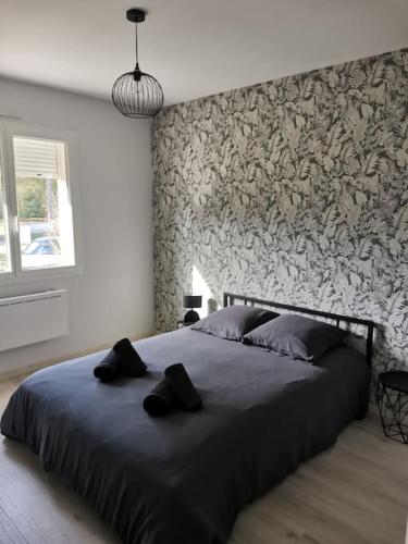 a bedroom with a large bed with a stone wall at La Maison du Bagas, 7pers in Vielmur