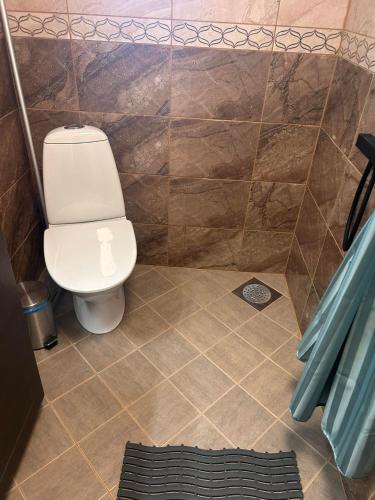 a bathroom with a toilet and a tiled floor at Valgemaja Majutus in Restu