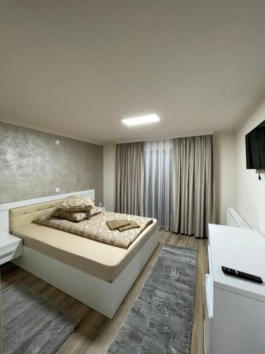 Un dormitorio con una cama grande y una ventana en Conacul Peștera Urșilor, en Chişcău