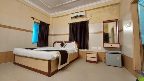 a bedroom with a bed and a mirror in it at Goroomgo Star Inn Puri in Puri