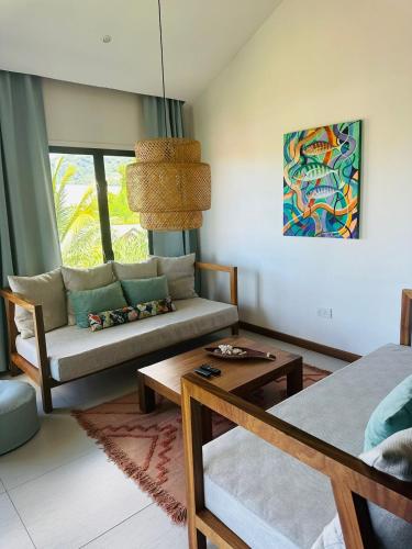 a living room with a couch and a table at Lodoicea Apartments in Bel Ombre