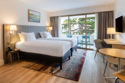 ein Hotelzimmer mit einem Bett und einem Balkon in der Unterkunft Staybridge Suites - Cannes Centre, an IHG Hotel in Cannes