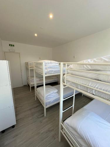 a room with three bunk beds in a room at Blife Faro Beach Hostel & Rooms in Faro