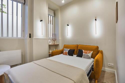 niewielka sypialnia z łóżkiem i oknem w obiekcie Apartment Montmartre by Studio prestige w Paryżu